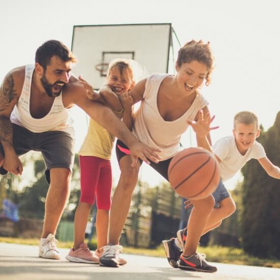 Family of four playing basketball together