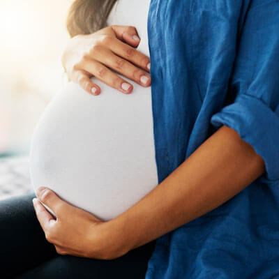 Pregnant person with hands on stomach
